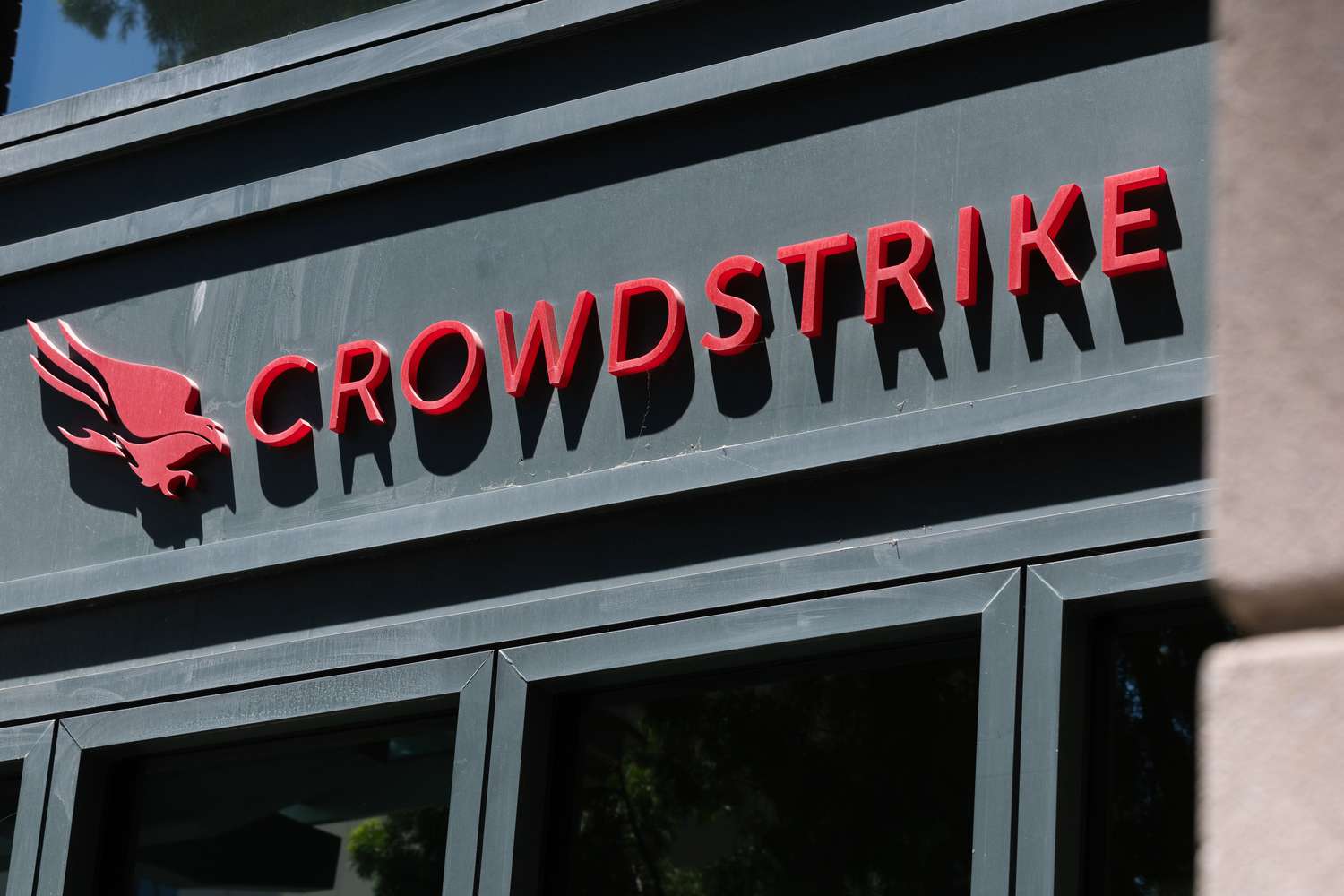 The red CrowdStrike logo is seen on the side of a black building.