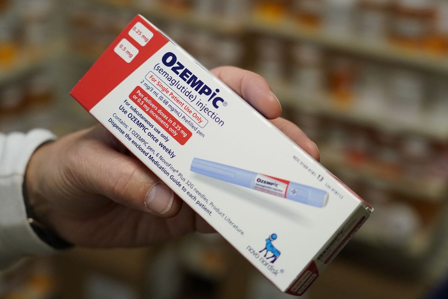 A pharmacist holds a box of Ozempic medication