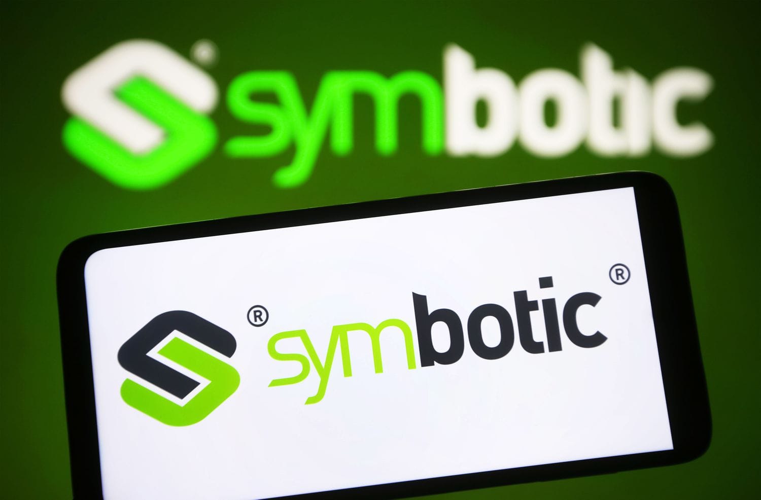 Symbotic logo is seen on a smartphone and in the background