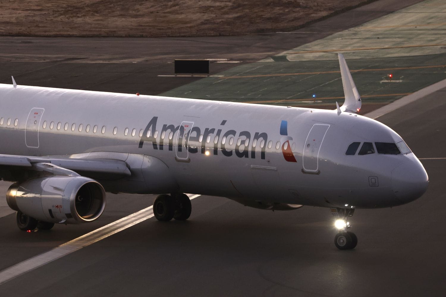 An American Airlines Airbus A321-231 airplane taxis to depart from San Diego International Airport to Dallas at sunset on Nov. 22, 2024 in San Diego, California