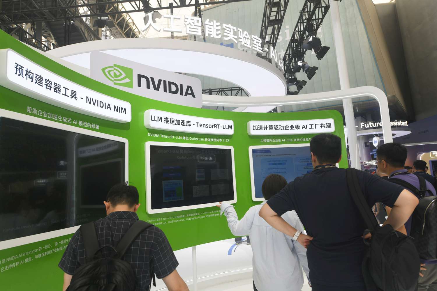 People stand in front of screens presenting videos about Nvidia products at a technology conference in China.