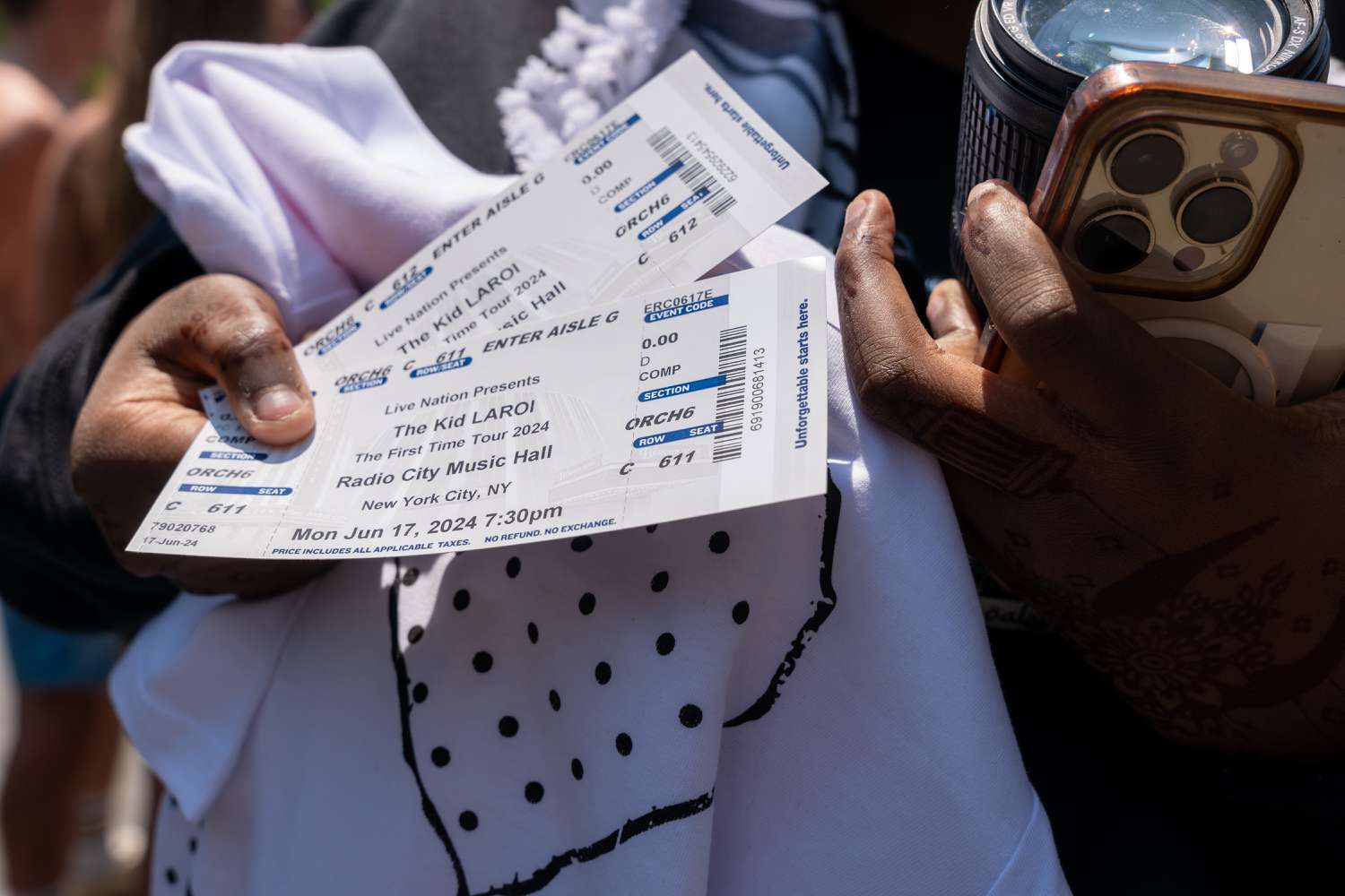 A woman displays her tickets as hundreds of people gather at Washington Square Park for a chance to see Australian rapper and singer The Kid LAROI