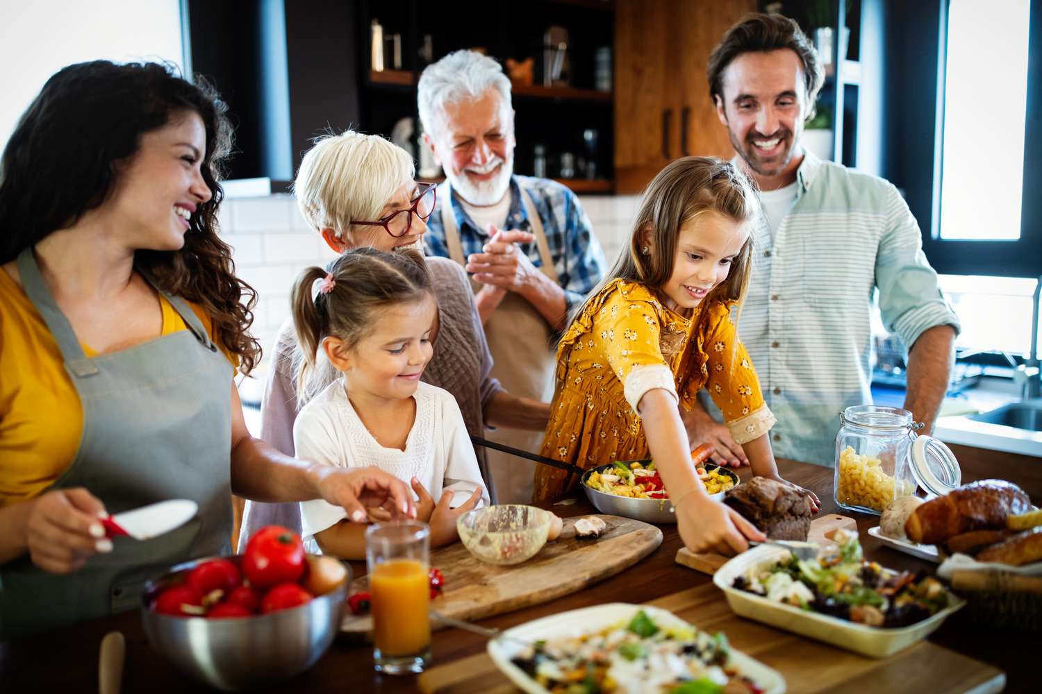 Grandparents, parents and children spending happy time in the kitchen. 