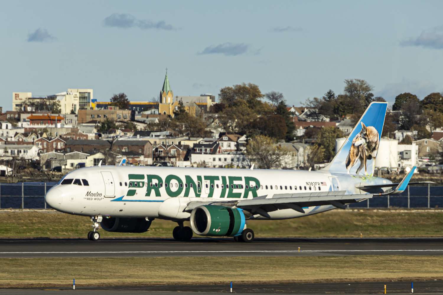 Frontier Airlines Airbus A320neo passenger aircraft spotted on final approach flying, landing and taxiing on the runway and taxiway of LaGuardia airport in NYC