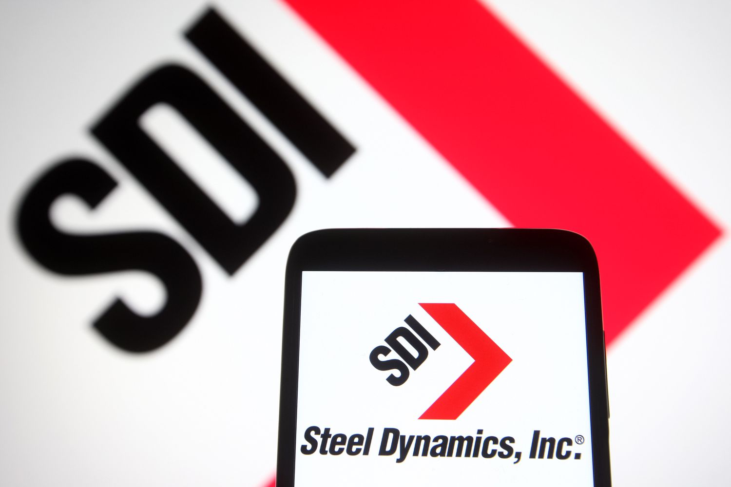 Steel Dynamics logo is seen on a smartphone and a pc screen