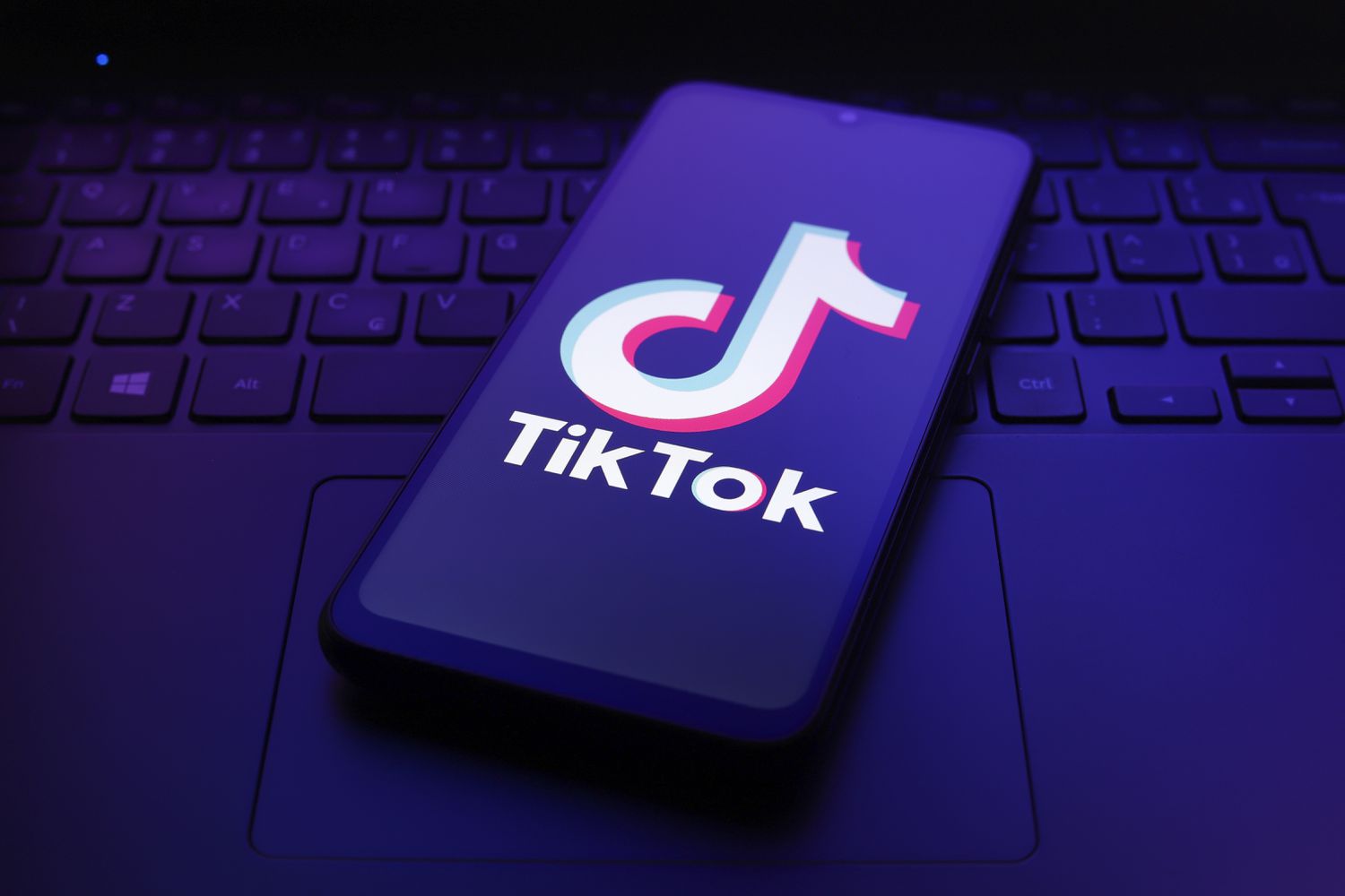 The TikTok logo appears on the screen of a smartphone