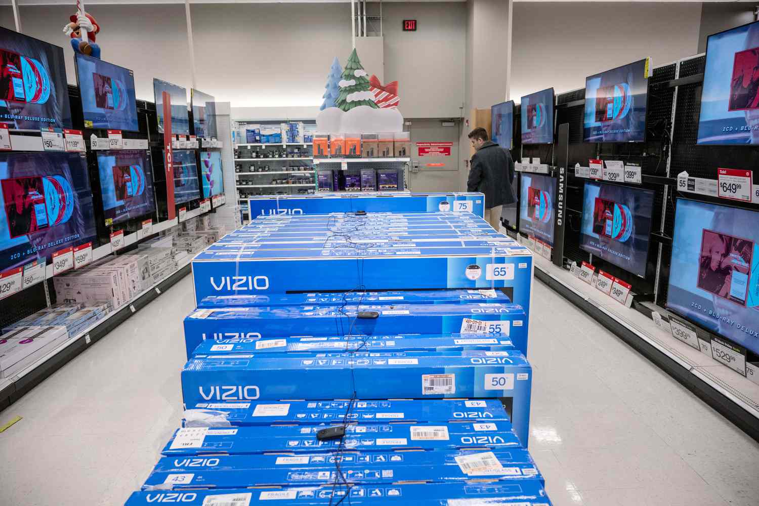 A shopper walks between aisles of TVs at a Target store.