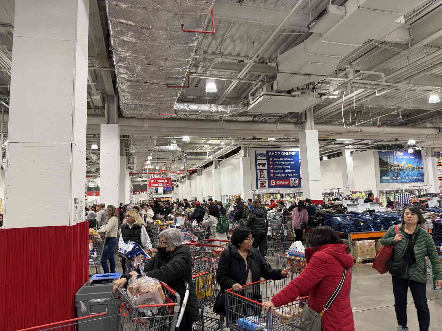 Customers lined up at checkout counters in very busy Costco store, Queens, New York