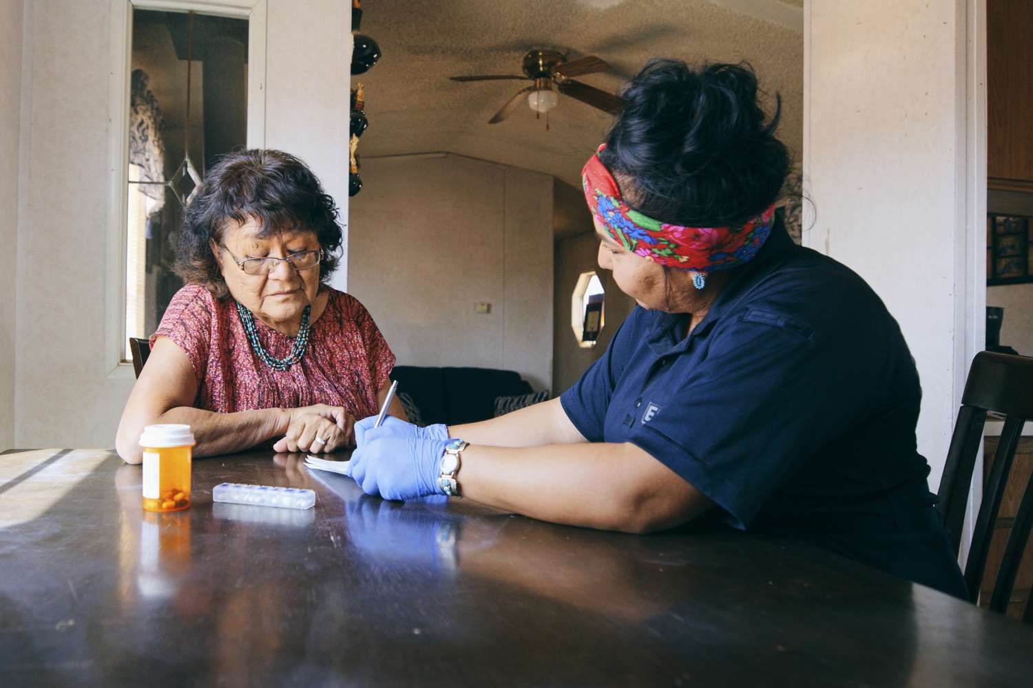 An older woman receives health care assistance in her home