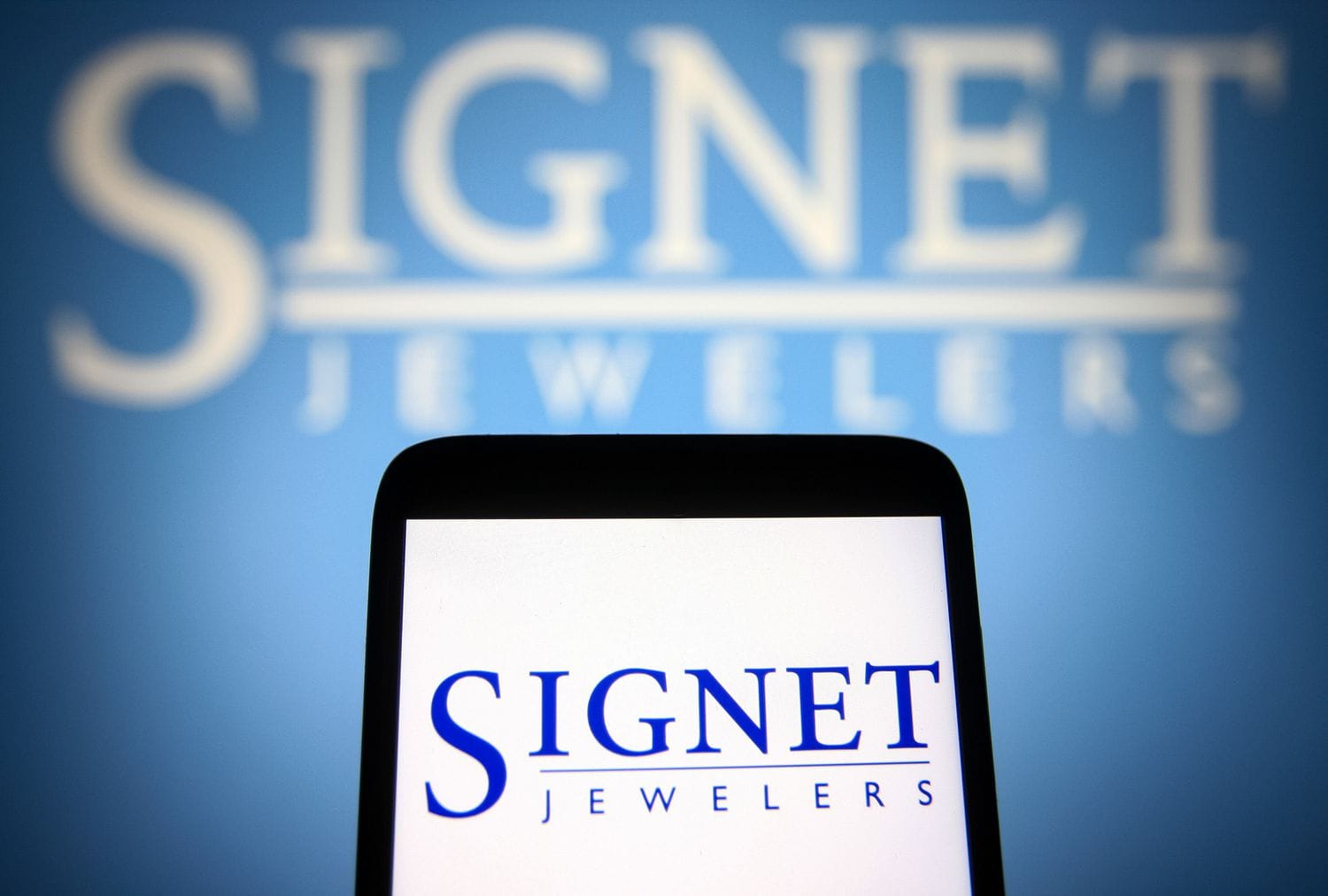 Signet Jewelers logo is seen on a smartphone and a PC screen