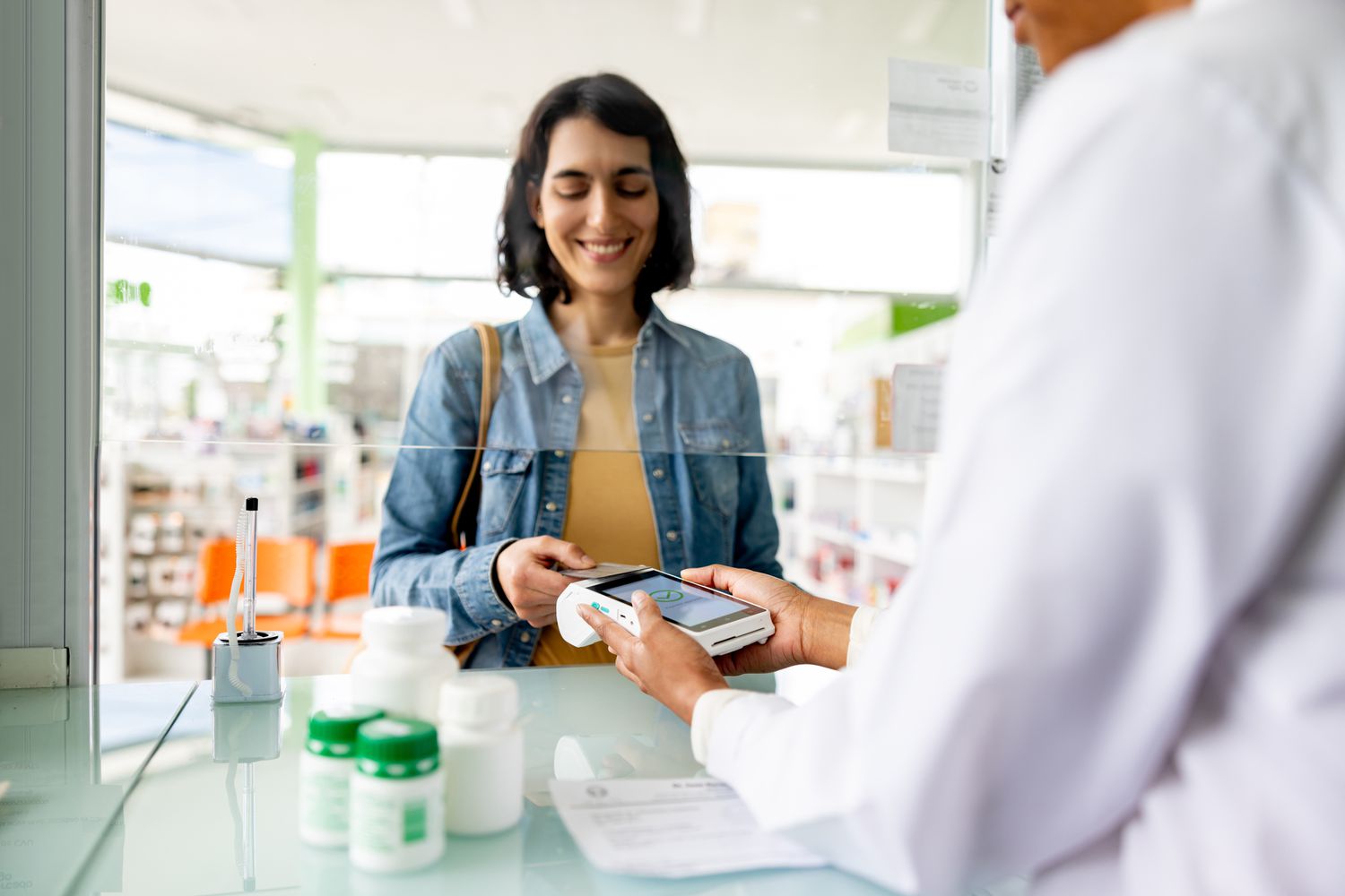  woman paying by card while buying medicines at the pharmacy