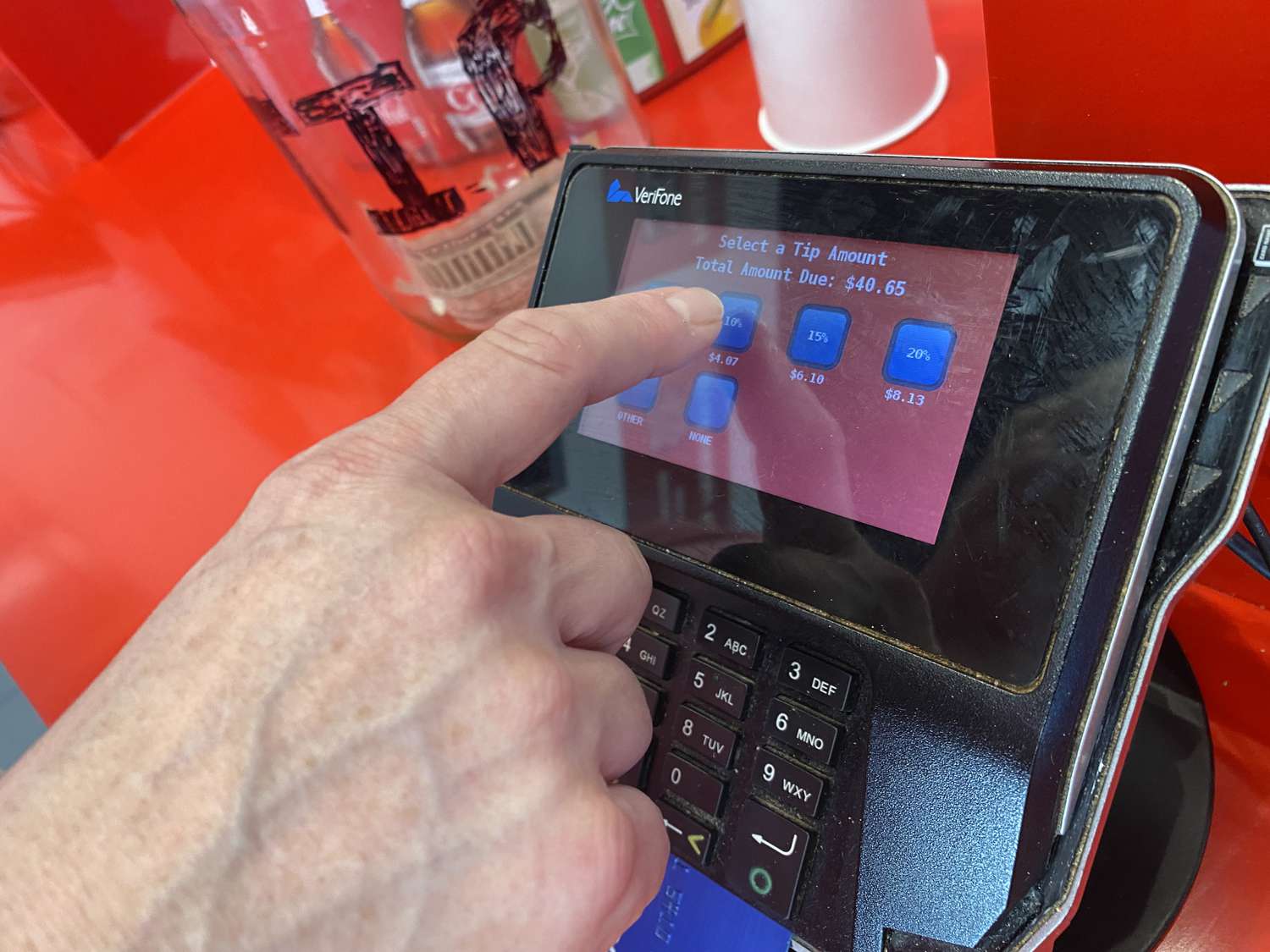 Person selecting a tip while using touch screen credit card payment at Five Guys restaurant, Queens, New York