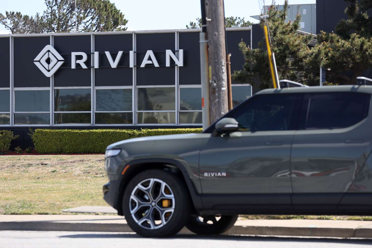 A Rivian electric pickup truck in a parking lot of a Rivian service center