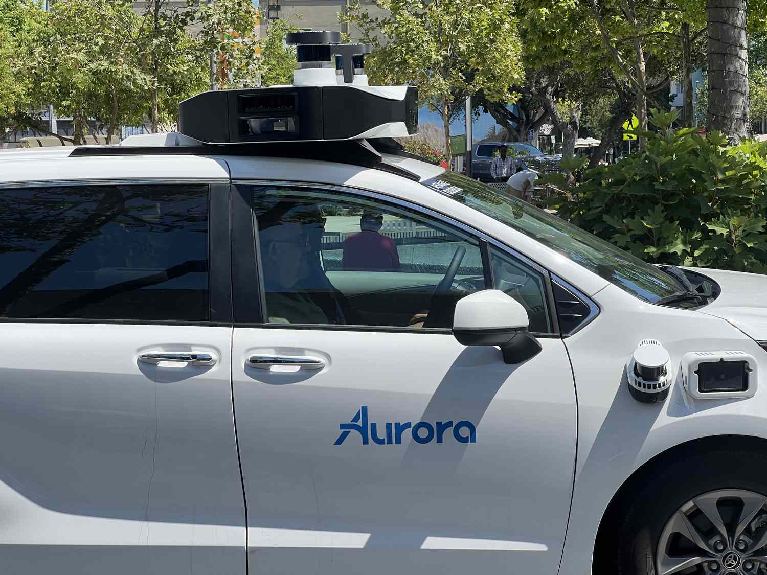 The blue Aurora logo is seen on the side of a self-driving vehicle from Aurora Innovation.