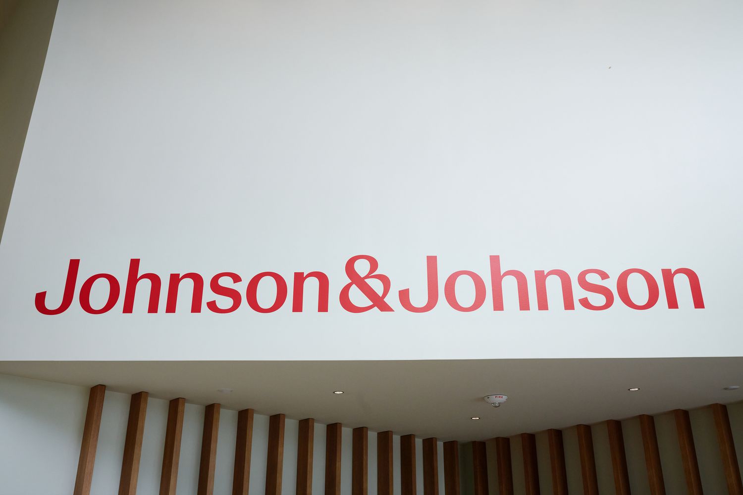 The Johnson & Johnson logo is seen in red text on a white wall.