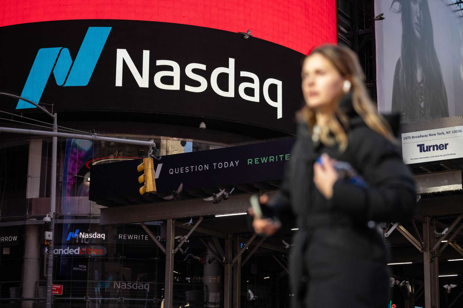 A person walks past Nasdaq headquarters in Times Square